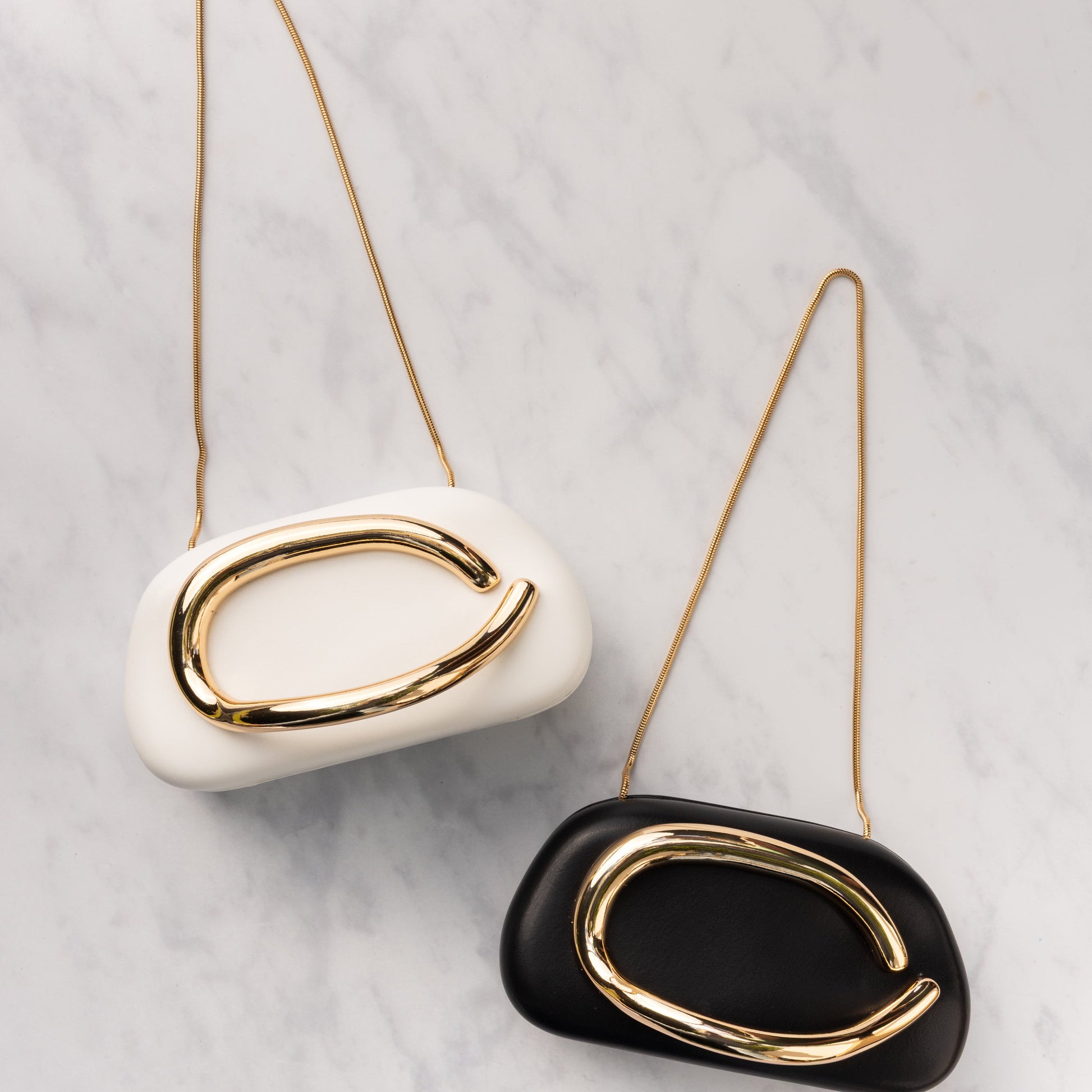 white and black box clutch purse with gold chain handle